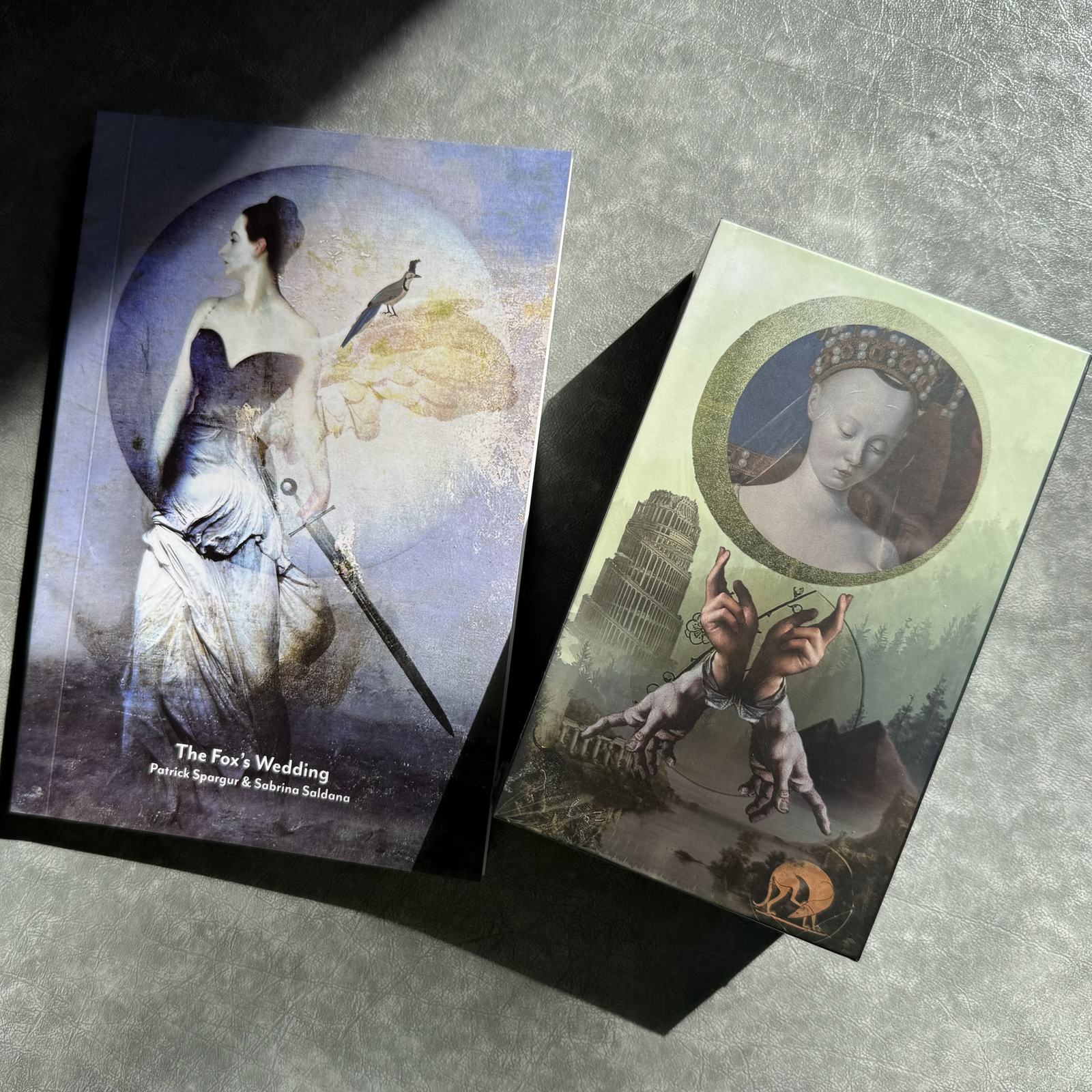 The Fox’s Wedding guidebook and tarot deck resting together in a shaft of sunlight